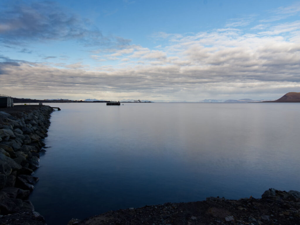 Longyearbyen, Spitzbergen: Arktische Landschaft mit Wasser, Felsen und bewölktem Himmel. Natur pur!