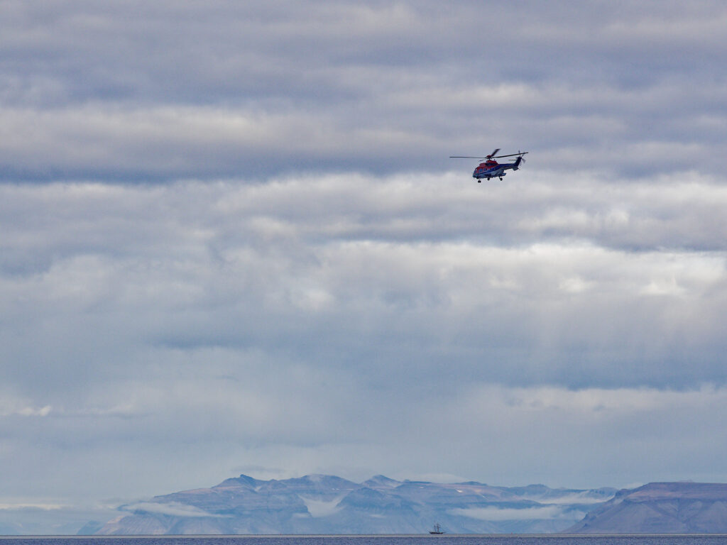 Helikopterflug über Longyearbyen, Spitzbergen. Arktische Landschaft mit Bergen und Wolken.