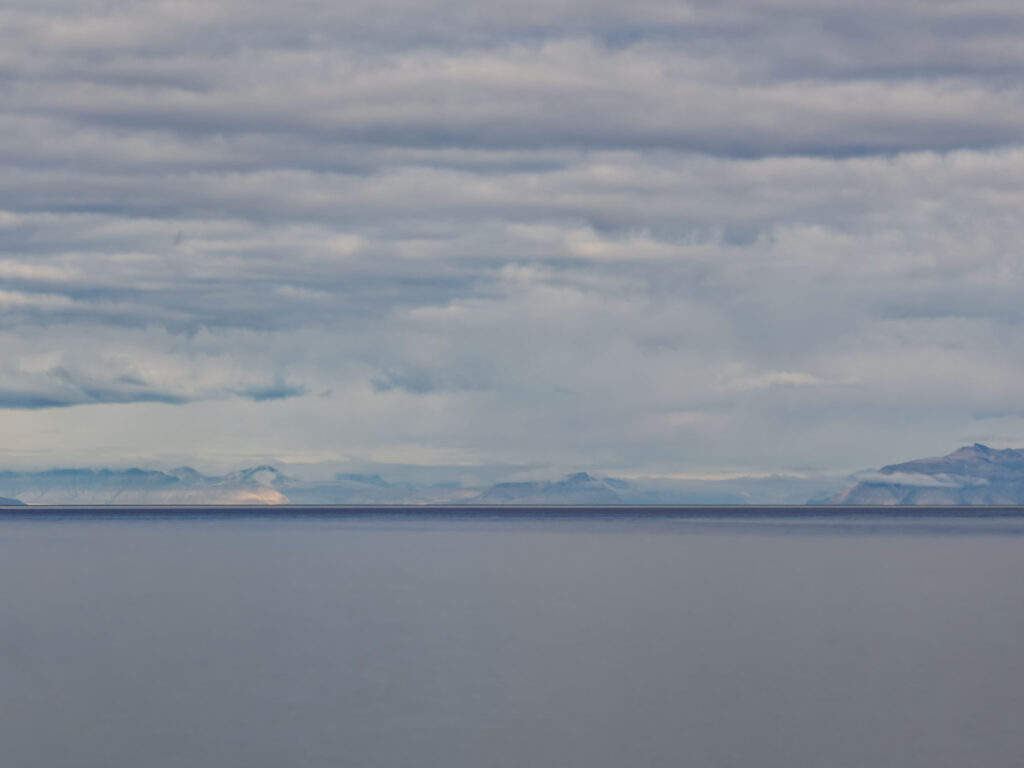 Longyearbyen, Spitzbergen: Arktische Landschaft mit Meer, Bergen und bewölktem Himmel. Polare Natur.