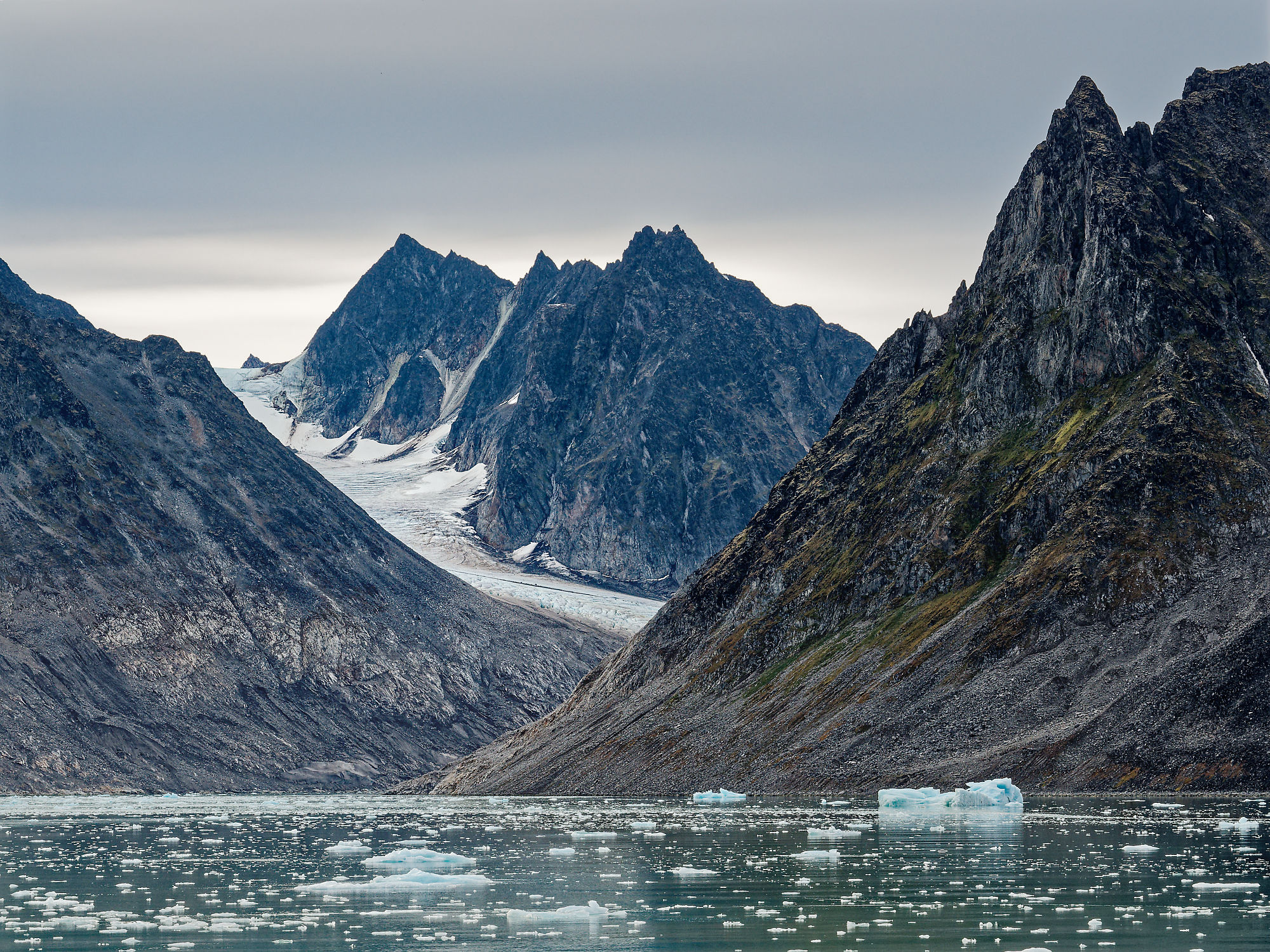 Magdalenefjord, Spitzbergen: Eisberge im Wasser, umgeben von Bergen und Gletschern. Arktische Landschaft.