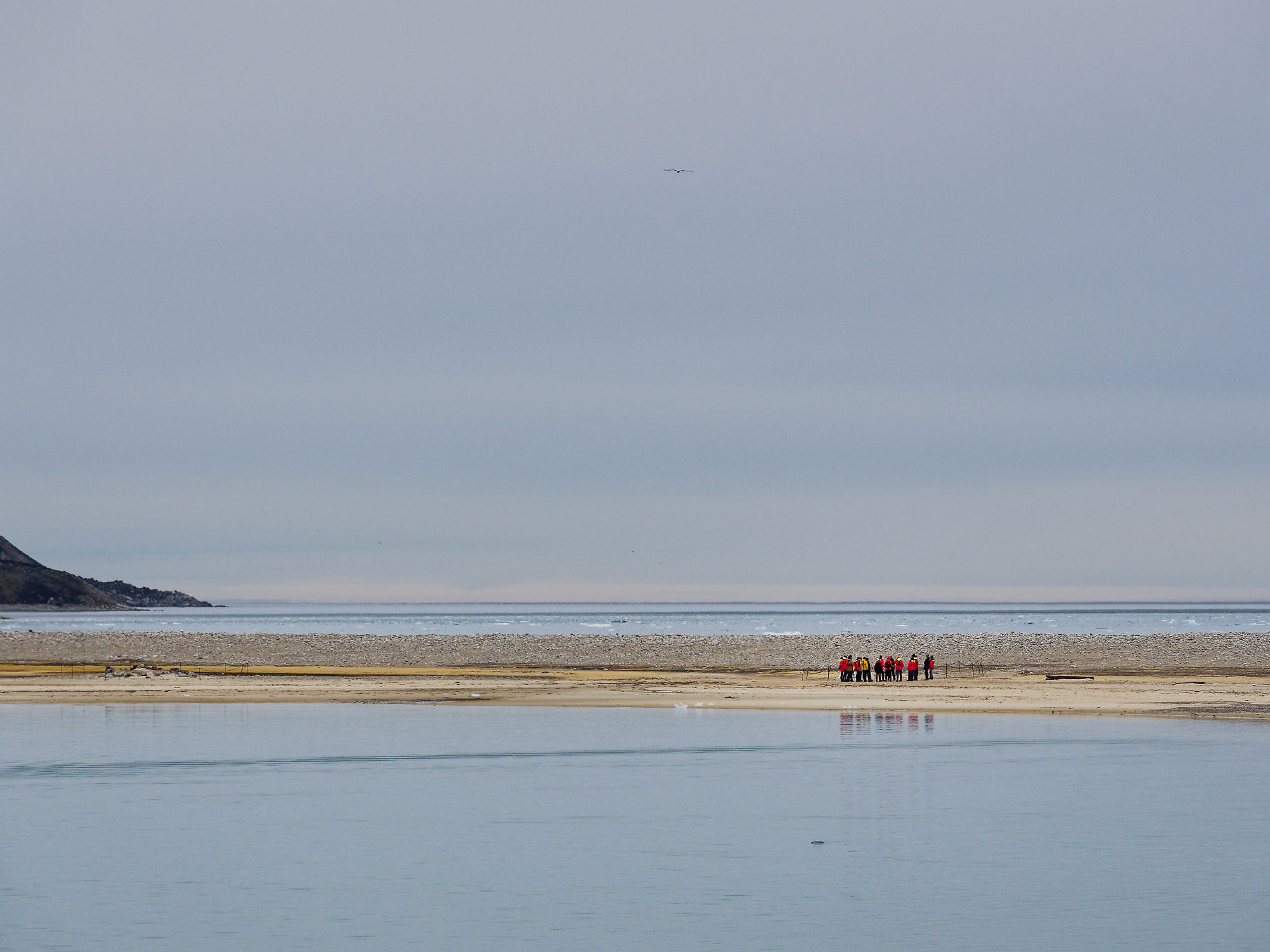 Magdalenefjord, Spitzbergen: Gruppe von Wanderern am Strand. Arktische Landschaft mit Wasser und Bergen.