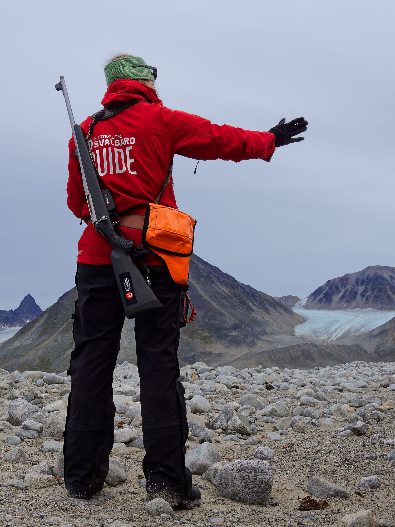 Svalbard Guide mit Gewehr in Magdalenefjorden, Arktis. Gletscher und Berge im Hintergrund. Outdoor-Abenteuer.