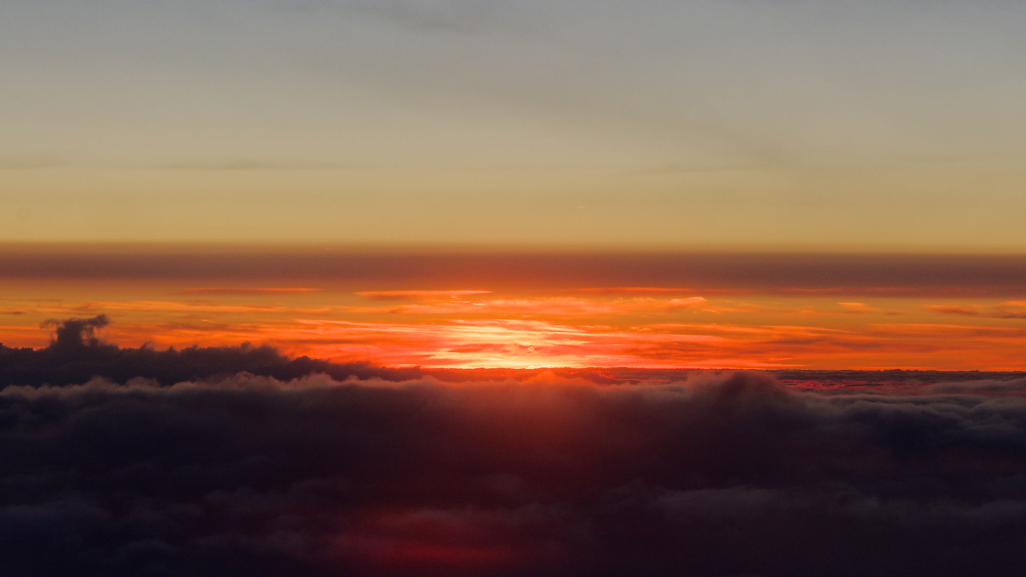 Sonnenuntergang über den Wolken. Roter Himmel bei Sonnenuntergang. Landschaft mit Wolken und Abendsonne.