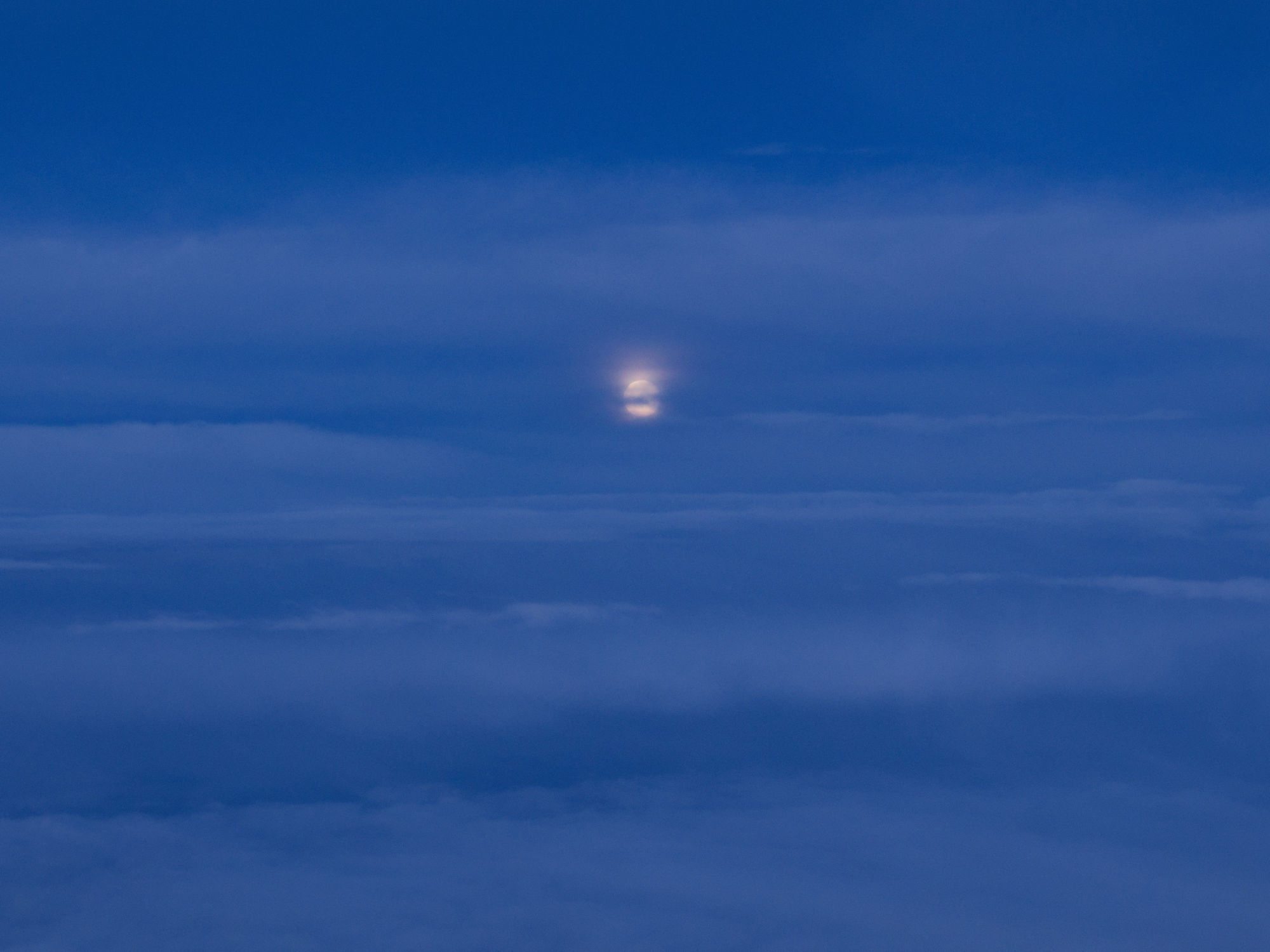 Blauer Himmel mit Wolken und einem Vollmond. Flugzeug über Wolken.