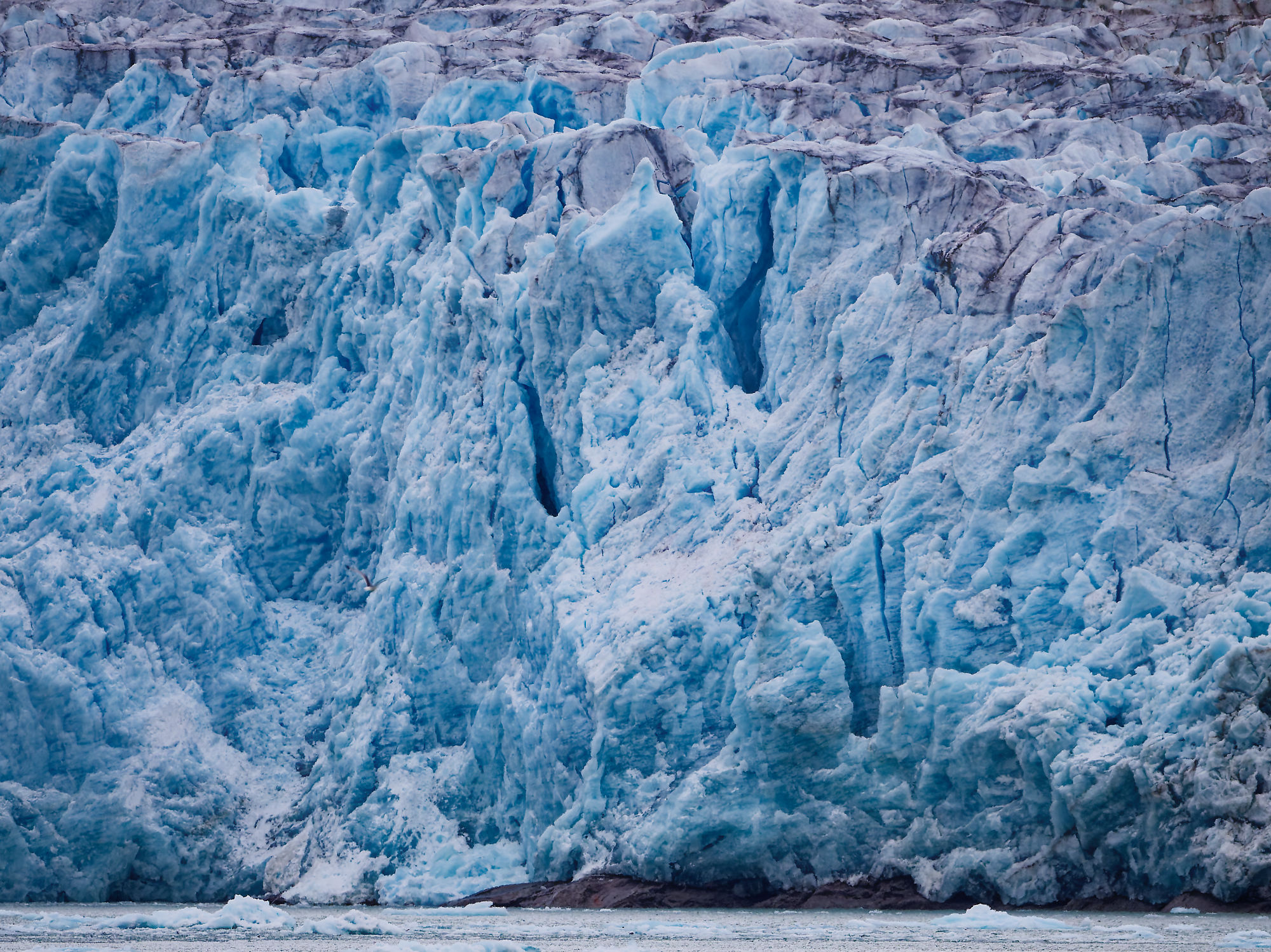 Nahaufnahme eines blauen Gletschers in Smeerenburgfjorden, Spitzbergen. Eisformationen und Texturen sichtbar.
