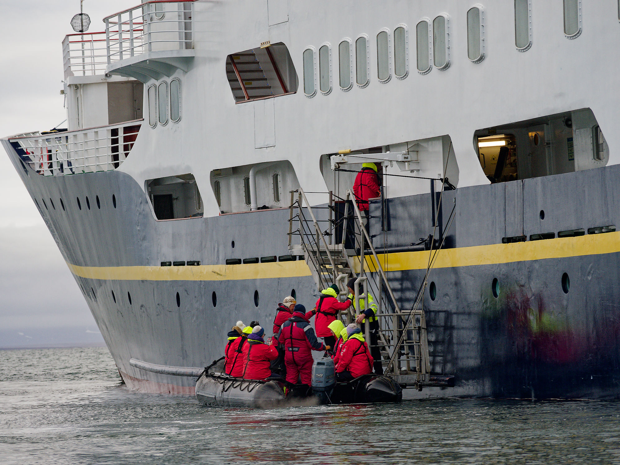 Kreuzfahrt: Schlauchboot bringt Passagiere zum Schiff. Expedition in die Arktis.